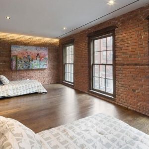 A simple bedroom with brick walls.