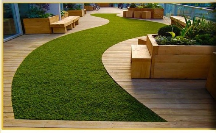 Artificial grass wooden theme garden on the backyard patio