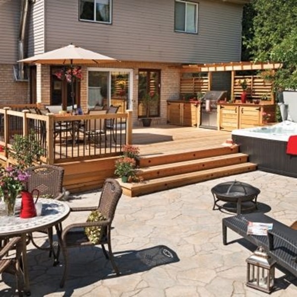 A wooden deck with Wood Back Drop and stone patio