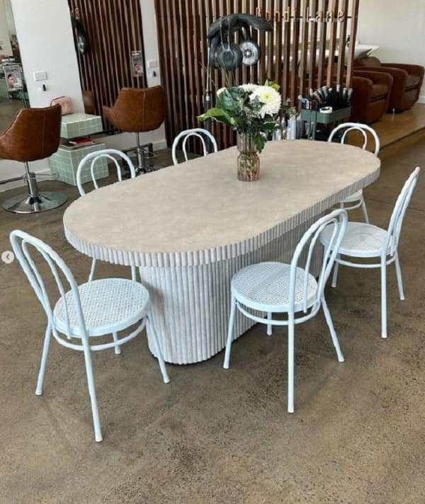 Oval concrete dining table with ribbed edges for 6 persons