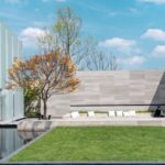 A backyard scene with artificial grass, clean landscaping, and a comfortable seating area designed for relaxation.