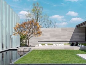 A backyard scene with artificial grass, clean landscaping, and a comfortable seating area designed for relaxation.