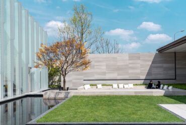 A backyard scene with artificial grass, clean landscaping, and a comfortable seating area designed for relaxation.