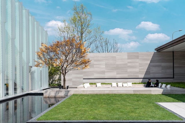 A backyard scene with artificial grass, clean landscaping, and a comfortable seating area designed for relaxation.