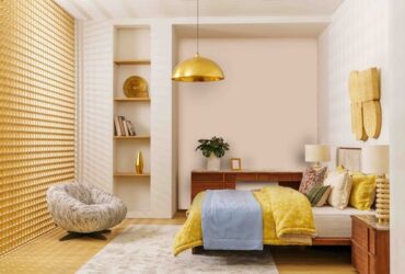 Bedroom Renovating with a Stylish Modern Design Featuring Wooden Bed, Yellow and Blue Bedding, Cozy Lounge Chair, and Warm Golden Lighting