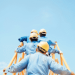 Construction workers in safety gear climbing scaffolding under a clear blue sky, symbolizing teamwork and improved workplace conditions.