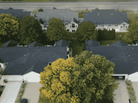 Aerial view of suburban homes with new dark-colored roofs, representing property value improvement through roofing investment.
