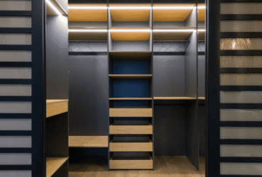 A modern walk-in closet featuring built-in shelves, drawers, and hanging space with integrated lighting.