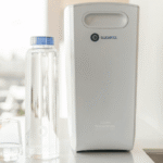 Compact home water filtration system placed on a kitchen counter beside a sink and reusable bottle, representing cleaner water and reduced household waste.