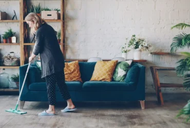 A woman cleaning living room carpet